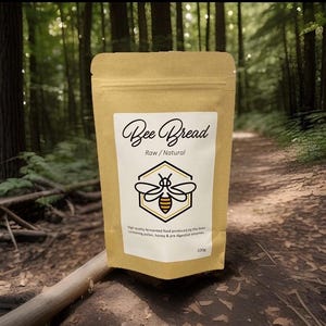 May include: A brown paper bag with a label that says "Bee Bread Raw/Natural". The label also features a bee illustration and the text "High quality fermented food produced by the bees containing pollen, honey & pre digestive enzymes. 100g".