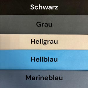 May include: A color chart featuring five horizontal bands of solid fabric in descending order: black, gray, light gray, light blue, and navy blue. Each band contains a centered text label in German: Schwarz, Grau, Hellgrau, Hellblau, and Marineblau.
