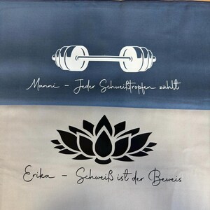 May include: Two rectangular towels, one blue and one light gray. The blue towel features a white barbell graphic and the text "Manni - Jeder Schwei&szlig;tropfen z&auml;hlt". The light gray towel displays a black lotus flower and "Erika - Schwei&szlig; ist der Beweis".