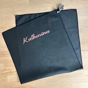 Pu&ograve; includere: Asciugamano in microfibra nero con il nome "Katharina" ricamato in lettere rosa.