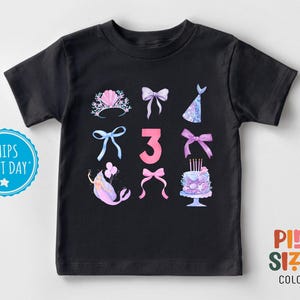May include: Black t-shirt with a pink number 3, mermaid, crown, cake, and bows. The text "Ships Next Day" is in the top left corner.