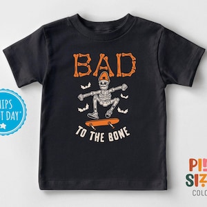 May include: Black t-shirt with a skeleton skateboarding and the text "Bad to the Bone".