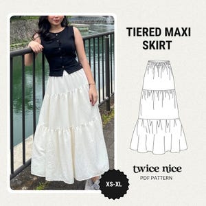 May include: A woman wearing a black sleeveless top and a white tiered maxi skirt. The skirt has a flowing, layered design. The image also includes a diagram of the skirt and the text "TIERED MAXI SKIRT" and "twice nice PDF PATTERN".