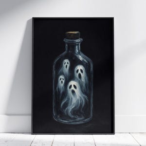 May include: A framed artwork featuring a dark background with a clear glass bottle. Inside the bottle are four white, ghostly figures. The bottle has a cork stopper. The artwork is displayed against a white wall and floor.