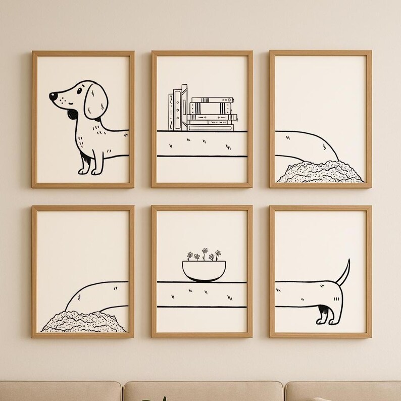 May include: A set of six framed art prints with simple black and white drawings. The prints depict a dachshund, books, a bowl of flowers, and abstract forms. The frames are light brown, and the background is off-white.