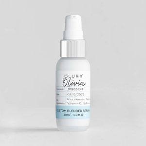 Puede incluir: Una botella blanca con una tapa de bomba plateada y una etiqueta que dice "OLURA Olivia" y "CUSTOM BLENDED SERUM 30ml - 1.0 fl oz".