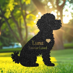 Puede incluir: Silueta negra de un caniche con el nombre "Luna" y las palabras "Forever Loved" grabadas en ella. La silueta está hecha de un material oscuro y tiene una forma de corazón recortada.