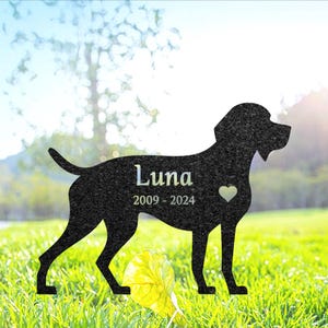 Puede incluir: Silueta negra de un perro con el nombre Luna y las fechas 2009 - 2024 grabadas en ella. Un pequeño corazón también está grabado en la silueta.