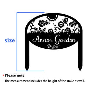 May include: A black metal garden stake featuring an arched top with a cutout design of flowers, a butterfly, and a sun. The text "Anne's Garden" is centered in the middle. A blue bracket indicates the total height including the two stakes.