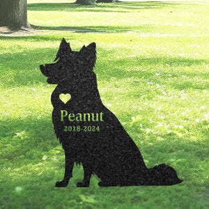 May include: Black silhouette of a dog sitting with a heart on its chest and the text "Peanut 2018-2024" below. The silhouette is on a green grassy background.