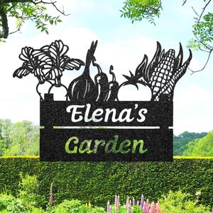 Può includere: Cartello da giardino in metallo nero con un design di verdure, tra cui barbabietole, cipolle, peperoni, un pomodoro e mais. Il cartello recita "Elena's Garden" in lettere bianche e verdi, adatto per la decorazione esterna.