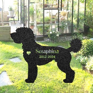 Könnte beinhalten: Schwarze Silhouette eines Hundes mit dem Namen "Seraphina" und den Daten "2012-2024" darauf gedruckt. Die Silhouette befindet sich auf einem grünen Rasen.