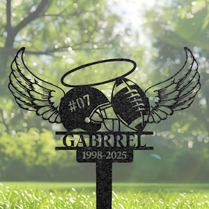 Può includere: Paletto da giardino in metallo nero con un casco da football, un pallone da football, ali d'angelo e un'aureola. Il nome "GABRIEL" e gli anni "1998-2025" sono incisi. Decorazione commemorativa per esterni.