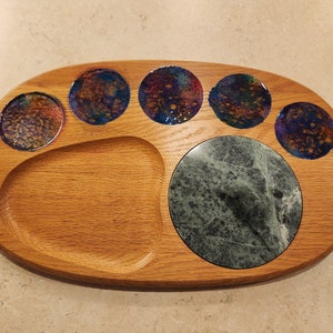 Peut inclure: Un plateau de service ovale en bois avec cinq incrustations circulaires de verre iridescent et une grande incrustation de marbre vert. Le plateau est en bois naturel.