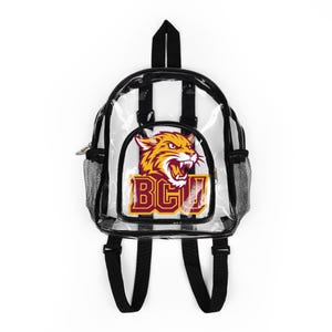 Puede incluir: Mochila transparente con rayas blancas y negras y ribetes negros. Presenta un parche frontal con un tigre rugiente y las letras "BGU" en granate y dorado. Incluye correas negras para los hombros y un asa superior.