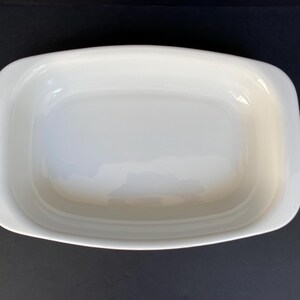 Może przedstawiać: Biała ceramiczna forma do pieczenia o prostokątnym kształcie i lekko zaokrąglonych krawędziach. Forma jest pusta i gotowa do pieczenia.