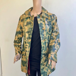 May include: A long-sleeved, tie-dye patterned jacket with a button closure. The jacket is made of leather and has a yellow and green color scheme.
