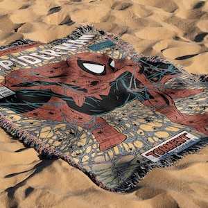 May include: A woven throw blanket featuring a vintage comic book cover of Spider-Man. The cover is red, blue and black with a yellow background. The text on the cover reads "Spider-Man" and "Torment Part One of Five".