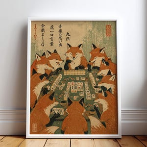Könnte beinhalten: Ein gerahmter Kunstdruck mit neun orangefarbenen Füchsen, die an einem grünen Tisch Mahjong spielen. Die Illustration enthält japanische Schriftzeichen in schwarzer Tinte, einen gedeckten grünen Hintergrund und einen roten Siegelstempel.