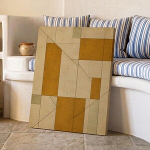 Könnte beinhalten: Ein rechteckiger Leinwanddruck mit einer geometrischen Komposition aus senfgelben, beigen und gedeckten salbeigrünen Blöcken, die durch dünne, dunkle Linien getrennt sind. Das Kunstwerk zeigt eine strukturierte Anordnung vertikaler und horizontaler Rechtecke.