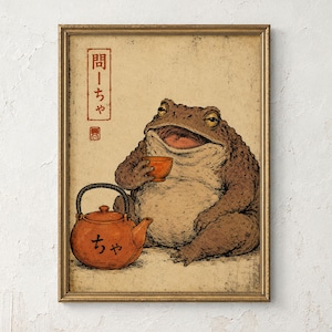 Könnte beinhalten: Ein gerahmter Kunstdruck, der eine braune Kröte zeigt, die neben einer orangefarbenen Teekanne sitzt und eine kleine orangefarbene Tasse hält. Die Illustration hat einen strukturierten, gealterten Papierhintergrund mit japanischen Schriftzeichen.