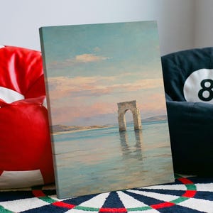 May include: A rectangular canvas print featuring a landscape painting of a stone arch standing in calm water under a soft pastel sky with pink and blue hues. The artwork depicts a serene coastal scene with distant land and gentle reflections.