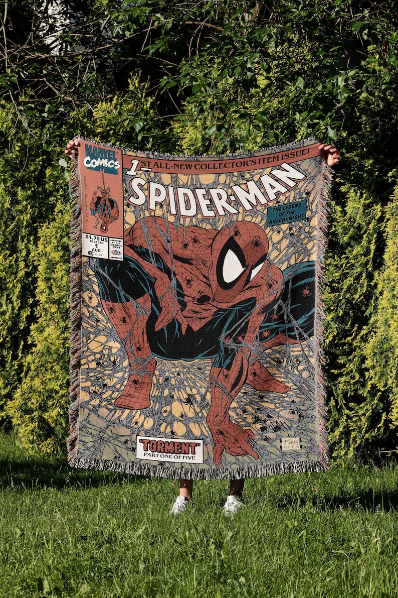 A Jacquard-woven blanket featuring a textured, intricate artwork woven into the fabric. The design showcases a stella comic design. The blanket appears thick and soft, suggesting it is both a decorative piece and a cozy item for warmth.