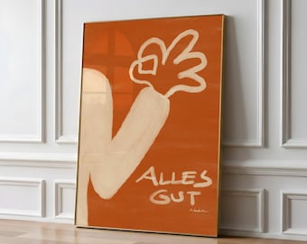 May include: Framed art print with an orange background, depicting a white arm and hand in an 'okay' gesture. The words 'Alles Gut' are written in white. The artwork has a minimalist style and is displayed against a white wall.