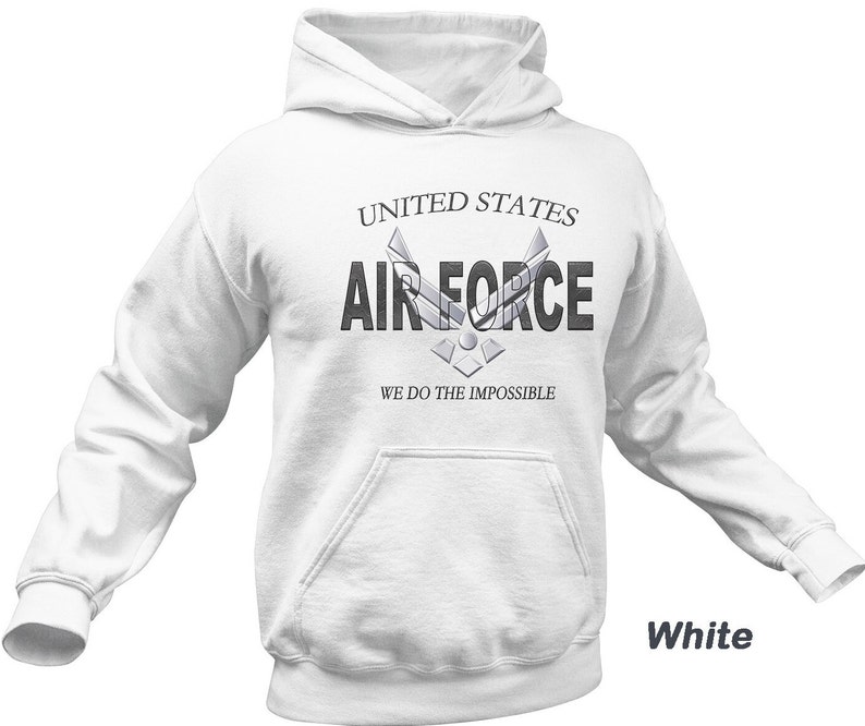 Może przedstawiać: Biała bluza z kapturem z napisem "United States Air Force" i logo Sił Powietrznych. Pod logo znajduje się napis "We do the impossible".