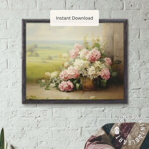 May include: A painting of a bouquet of pink and white hydrangeas in a wicker basket. The flowers are arranged in a vase on a stone floor. The background is a blurry landscape with green fields and a blue sky.