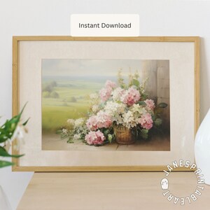 May include: A framed print of a still life painting featuring a basket of pink and white flowers. The flowers are arranged in a wicker basket and are set against a backdrop of a green field and a blue sky.