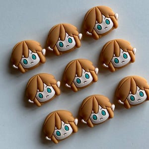 May include: Nine brown and white cartoon character faces with blue eyes. The characters have brown hair and are smiling.