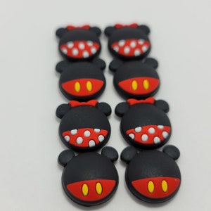 May include: Eight black and red Mickey Mouse character charms with white polka dots. The charms are made of silicone and have a flat back.