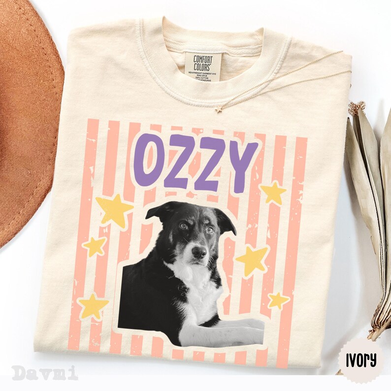Peut inclure: Un t-shirt &agrave; manches courtes couleur ivoire avec une impression graphique repr&eacute;sentant un chien noir et blanc. Au-dessus du chien, le nom OZZY est imprim&eacute; en lettres violettes. Le fond du motif pr&eacute;sente des rayures p&ecirc;che et des &eacute;toiles jaunes.