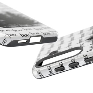 May include: Two white phone cases with a black and white design. The cases have a repeating pattern of the word "BOLL" in a stylized font. The cases have black edges and cutouts for the phone's features.