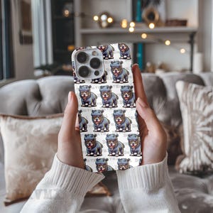 Puede incluir: Carcasa blanca para iPhone con un patr&oacute;n repetido de hipop&oacute;tamos de dibujos animados que llevan su&eacute;teres azules y blancos. Los hipop&oacute;tamos est&aacute;n todos mirando hacia adelante y tienen una expresi&oacute;n feliz. La carcasa tiene una lente de c&aacute;mara negra.