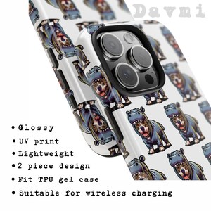 Puede incluir: Una funda de tel&eacute;fono blanca con un dise&ntilde;o de dos piezas que presenta un patr&oacute;n repetido de hipop&oacute;tamos de dibujos animados que llevan sudaderas con capucha azules. La funda es compatible con la carga inal&aacute;mbrica y tiene un acabado brillante.