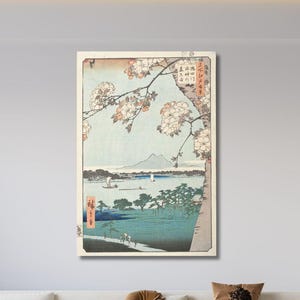 May include: A rectangular wall art print featuring a Japanese woodblock style landscape. The scene depicts cherry blossoms in the foreground, a calm body of water with small boats, distant mountains, and figures walking along a path, with Japanese text.