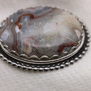 Polished agate cabachon lapel pin, brooch. Set in silver tone setting.