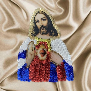 May include: A red, white, and blue sequined patch featuring a depiction of Jesus Christ with a heart in his chest. The patch is surrounded by gold sequins.