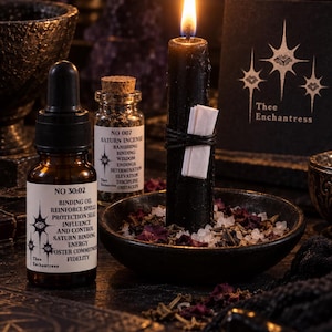 May include: A black candle with a white paper scroll tied by black string, sitting in a dark bowl with salt and dried petals. Beside it is a brown glass dropper bottle labeled NO 30:02 Binding Oil and a small glass vial labeled NO 007 Saturn Incense.