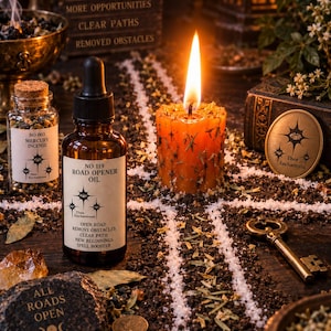 May include: A brown glass dropper bottle labeled NO 119 ROAD OPENER OIL, a small glass jar of NO 003 MERCURY INCENSE, an orange pillar candle with embedded herbs, a brass key, a round coin, and a dark stone engraved with ALL ROADS OPEN.