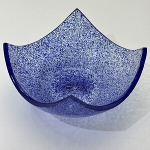 Peut inclure: Un bol en verre bleu avec un motif blanc mouchet&eacute;. Le bol a une forme unique avec cinq points.