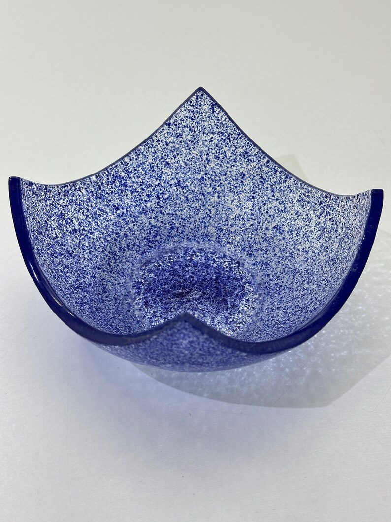 Peut inclure: Un bol en verre bleu avec un motif blanc mouchet&eacute;. Le bol a une forme unique avec cinq points.