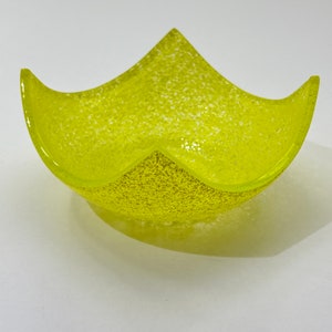 Peut inclure: Un bol en verre jaune avec une texture mouchet&eacute;e. Le bol est en forme d'&eacute;toile et a une ouverture large et peu profonde.