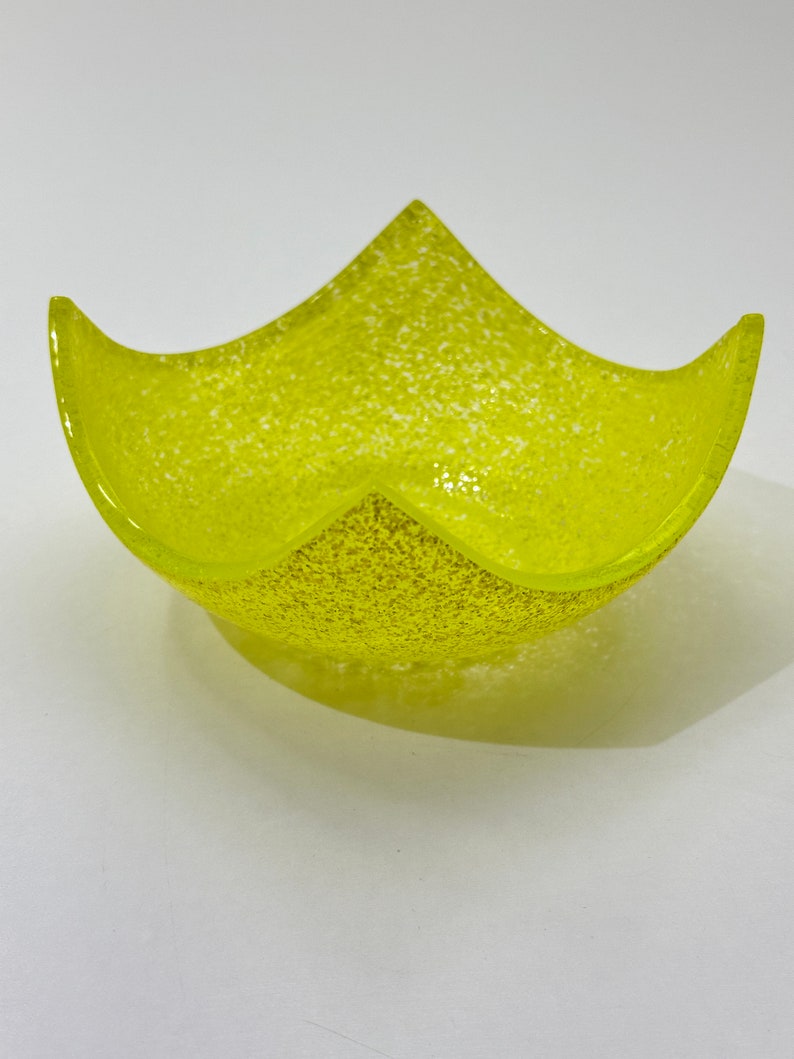 Peut inclure: Un bol en verre jaune avec une texture mouchet&eacute;e. Le bol est en forme d'&eacute;toile et a une ouverture large et peu profonde.