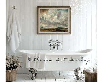 May include: A clawfoot bathtub with the text "Bathroom Art Mockup" on the side. A framed landscape painting hangs above the tub. A white towel is draped over the tub, and a basket of flowers sits nearby.