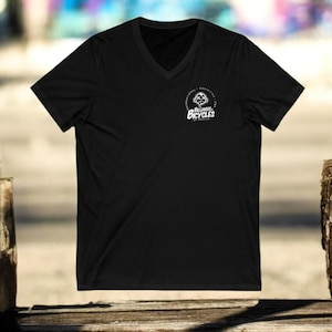 May include: A black V-neck t-shirt featuring a white circular logo with the text "Billiards Bicycles". The logo includes a mountain graphic. The shirt is displayed on a wooden surface.
