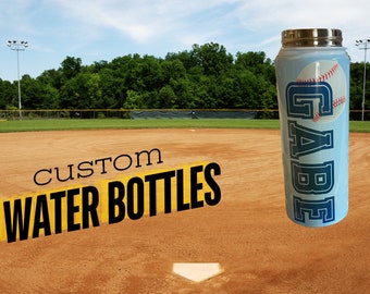 May include: A blue and white custom water bottle with a baseball graphic and the name "GAEB" printed on it. The bottle is on a baseball field.