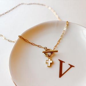 Delicado collar con cruz dorada: minimalista cadena de acero inoxidable chapada en oro de 18k con cierre de palanca y clip de papel.